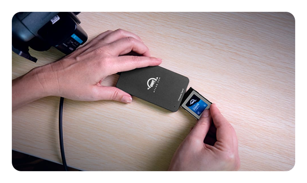 someone inserting a memory card into the OWC Atlas FXR