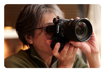 someone taking a photo with the Panasonic LUMIX S1IIE
