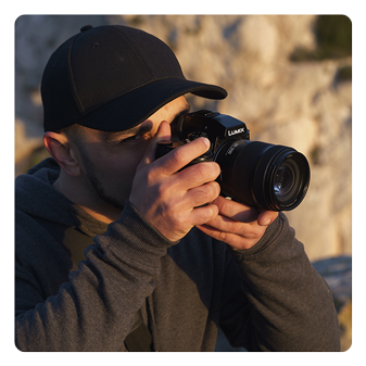 someone using the lumix lens attached to a camera