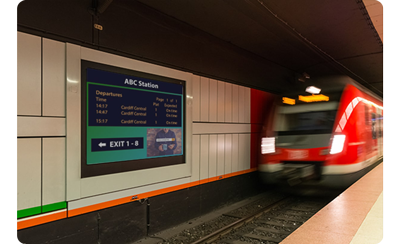 A digital signage screen on the far side of underground train