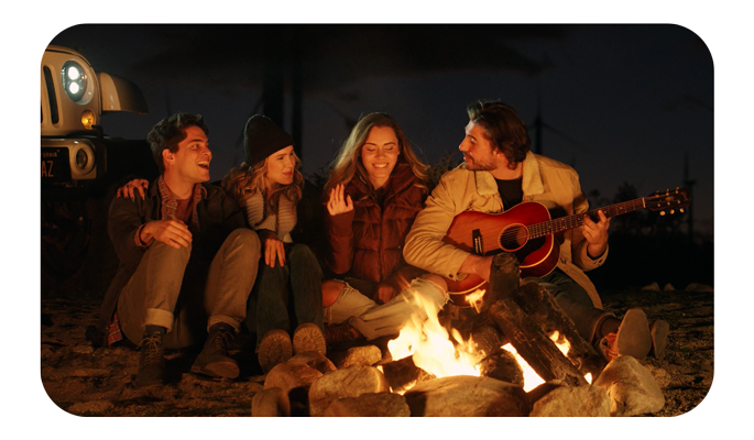 a group of friends sat around a campfire playing accoustic guitar, samyang xeen meister 14mm t2.6 lens