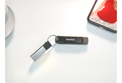 sandisk ixpand flashdrive luxe on keyring next to iphone on white table