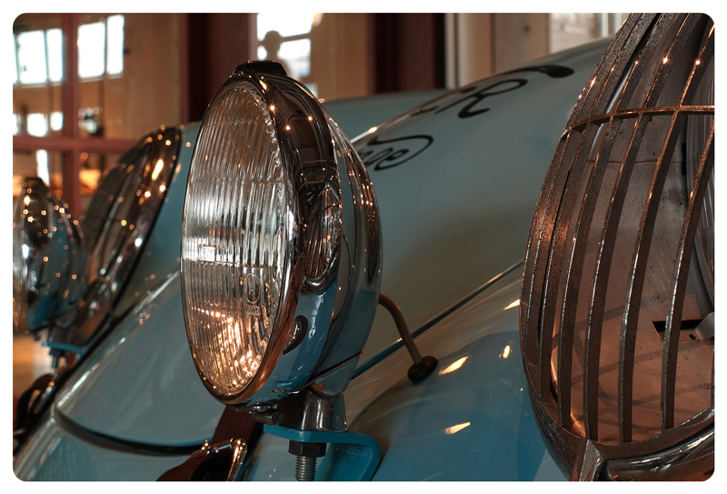 Close up of light blue porsche 911 safari rally car front head lights