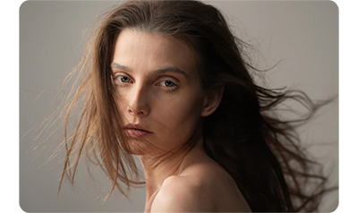 sony a1 sample image portrait of white woman with brunette hair blowing in the wind in a photography studio