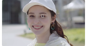 portrait photo of a woman wearing a white hat and showing the Sony ZV-E10s Eye autofocus marker