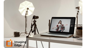 Sony Alpha camera set up in a photography studio with lighting umbrellas and laptop on a table