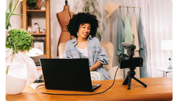 Woman using zv-e10 with a laptop for video conferencing or content creation in her fashion business