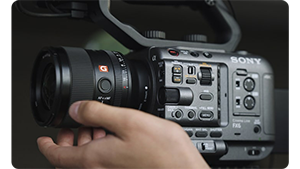 videographer adjust the lens on a Sony FX6