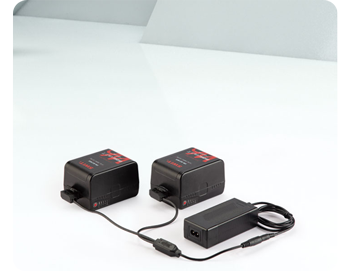 two Swit batteries connected to D-Tap charger on white table