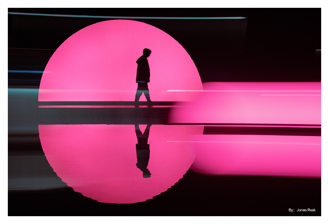 sample image of someone ralking in front of pink circle light taken with the ttartisan af 35mm f1.8 lens