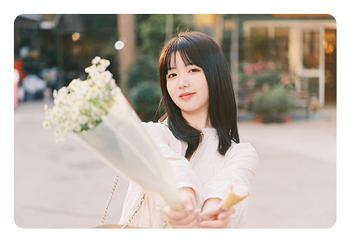 example image of a woman holding flowers taken with the AF 56mm F1.8 APS-C camera lens
