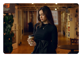 eample portrait of a woman holding a cup of coffee taken with the AF 56mm F1.8 APS-C camera lens