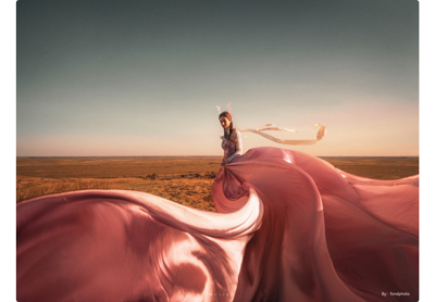 TTArtisan 10mm F2 ASPH sample photograph wide angle portrait of woman wearing flowing long pink dress standing in vast desert