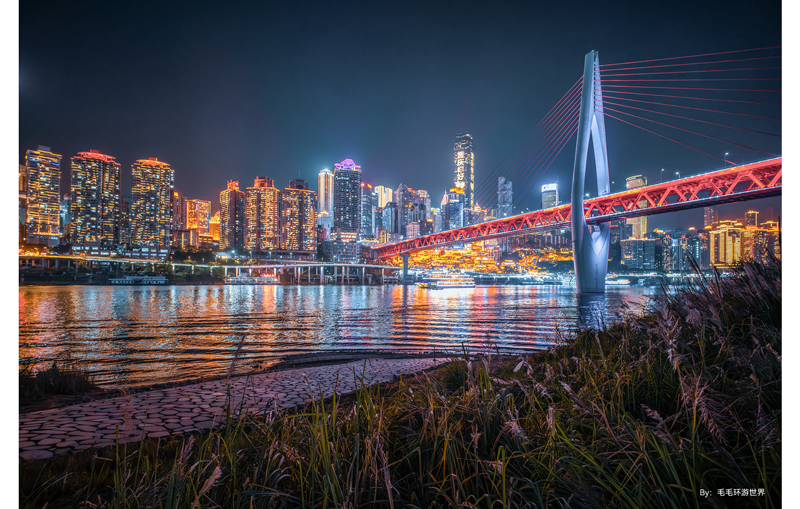 TTArtisan 10mm F2 ASPH sample photograph of city skyline at night with bridge crossing a river all illuminated by lights