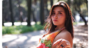 TTArtisan 35mm f0.95 sample photograph of brunette woman reclining on park bench on bright sunny day