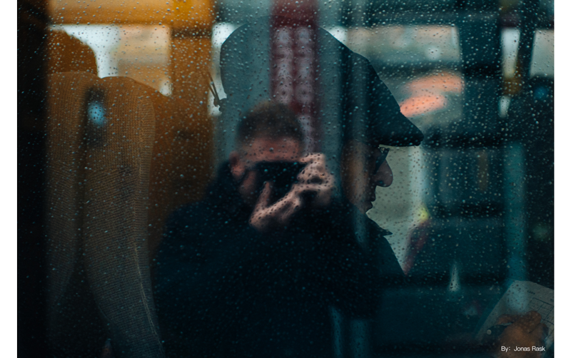 TTArtisan 35mm f0.95 sample photograph of photographer looking through bus window at man sitting writing in book