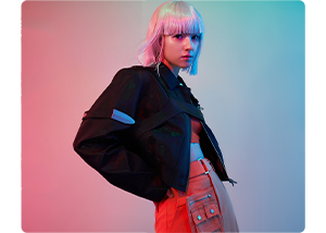 image of young woman wearing orange pants and crop top with black techwear jacket against Pink and blue lit background
