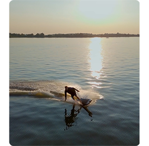 sunset photo of surfer on the water turning towards camera, shot on dji mini 4 pro