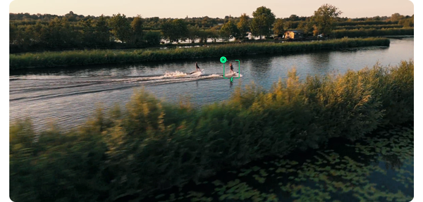 two surfers travelling down a river with dji tracking icon overlayed around them