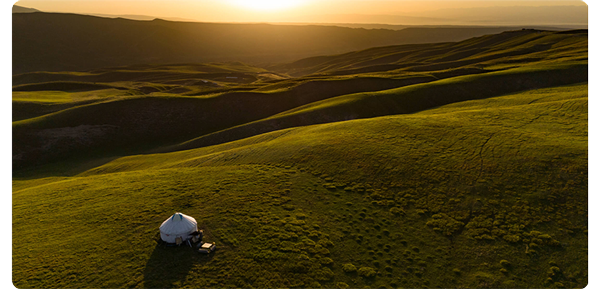 sample images from dji mini 4 pro, vibrant green hill landscape with a single white tent in the foreground