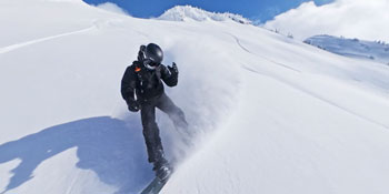 Snowboarder travelling down slope