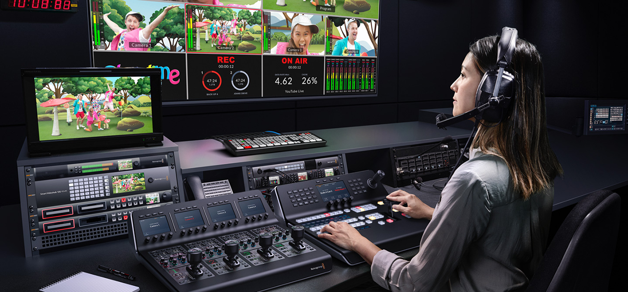 someone sat at a broadcast desk using the ATEM 1 M/E ADVANCED PANEL