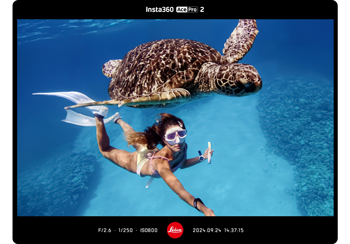 insta360 ace pro 2 sample image of female diver swimming with large sea turtle in clear blue ocean