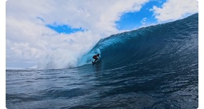 still image of surfer riding barrel waves