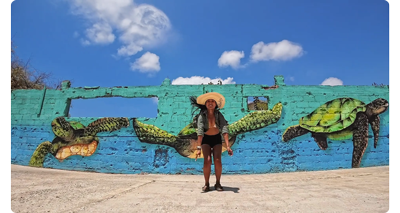 sample image of woman standing in front of street art wall with sea turtle mural