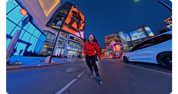 night time photograph of female roller skater riding through city streets at night