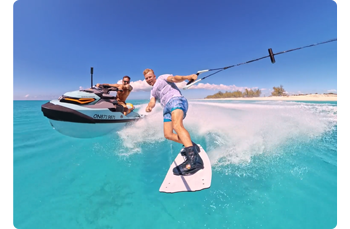 wake boarder and jetski rider on clear blue caribean ocean waves