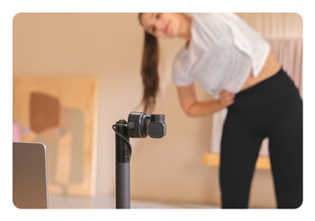 OBSBOT Tiny 2 Lite 4K webcam on a tripod being used in a yoga studio
