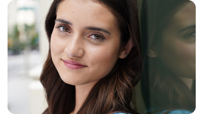 Sony a6600 sample image portrait of brunette woman leaning against glass window looking directly at camera