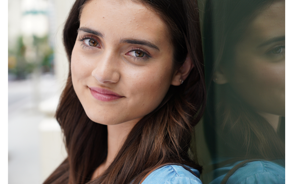 Sony E 16-55mm F2.8 G Lens Sample Image portrait of brunette haired woman leaning against glass window