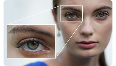 Sony FE 135mm F1.8 GM Lens sample photograph portrait of brunette woman with a zoom crop on her green eye
</div>
<div class=