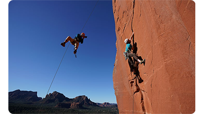Sony FE 16-35mm F2.8 GM Lens sample image of rock climbers scaling a sheer rock face and one repelling down taking photographs