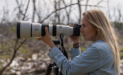 someone taking a photo using the sony super telephoto lens