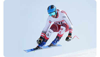 Sony FE 600mm F4 G Master OSS Lens sample image of speed slalom skiier wearing white and red uniform with blue helmet and boots