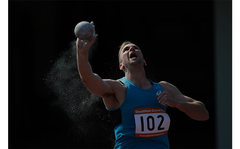 Sony FE 600mm F4 G Master OSS Lens sample image of male athlete throwing shotput wearing teal vest top with decathlon grand prix number