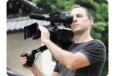 filmmaker adjusting focus on Sony FE PZ 28-135mm Lens mounted to sony FX6 professional camera