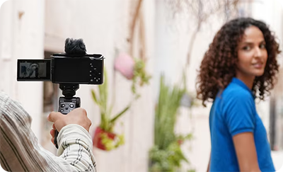someone takign a photo using the sony zv e10 ii with grip