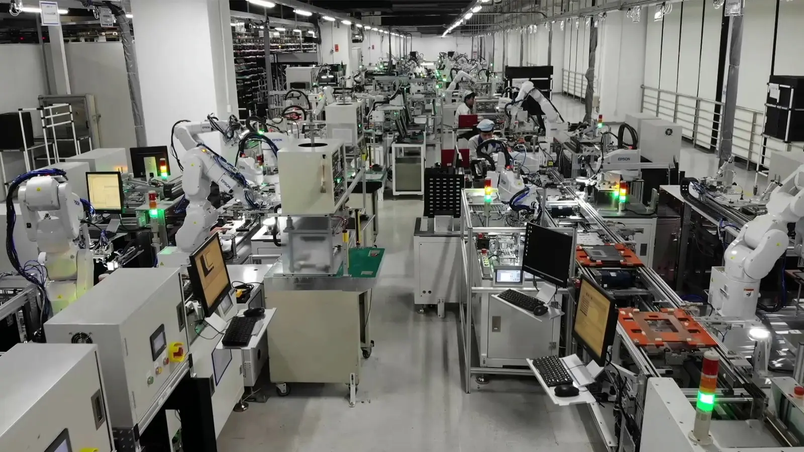 Robotic arms performing automated assembly and inspection on a factory production line