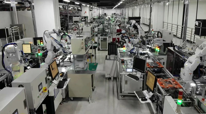 Industrial robotic arms at work on a manufacturing production line.