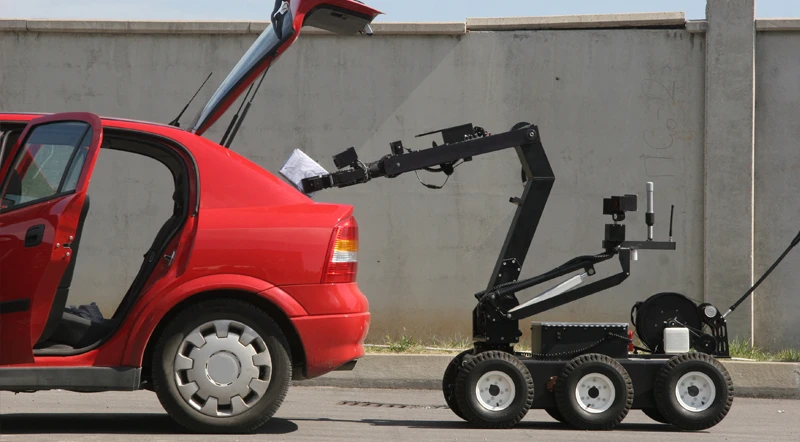 Remote-operated bomb-disposal robot inspecting a vehicle.