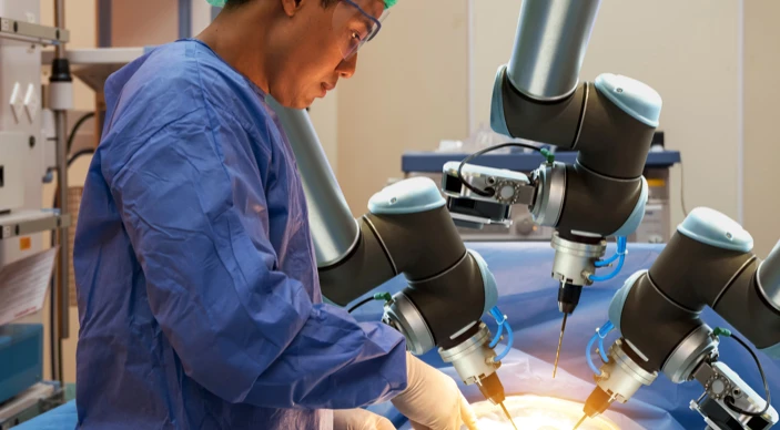 Robotic surgical equipment assisting clinicians in an operating theatre.