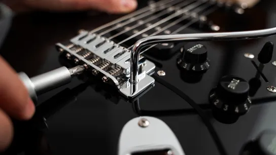 Technician performing a professional guitar setup
