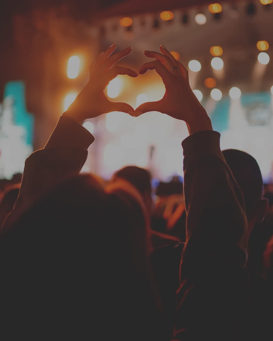 girl at event making a love symbol