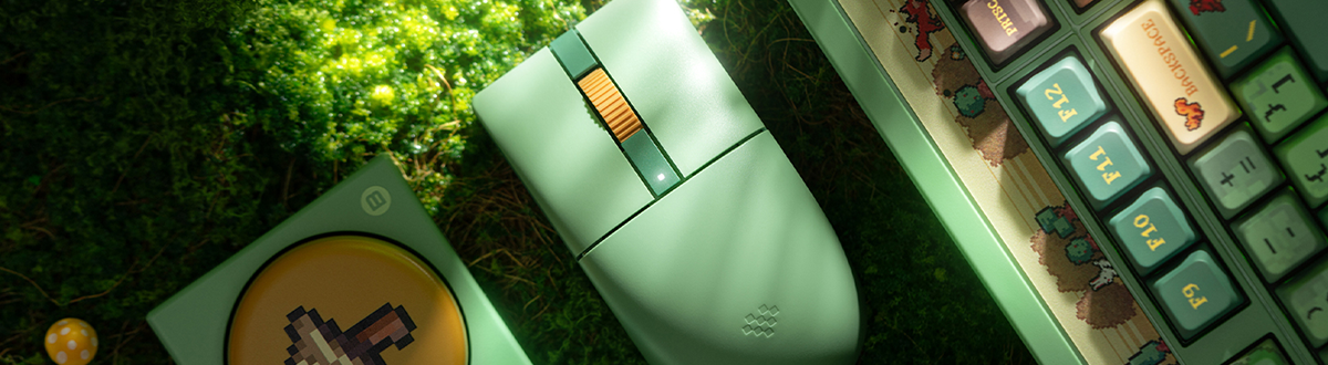 Key visual of retro mouse, keyboard and super button collection atop grassy surface.