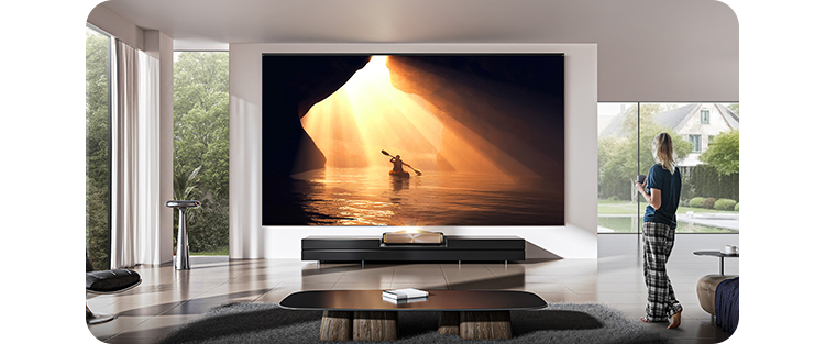 Lifestyle image of a woman viewing the projector in a living room setting