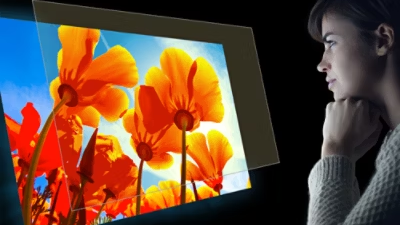Woman in dark setting, looking at floral projection overlaid with BlueLightShield screen illustration.